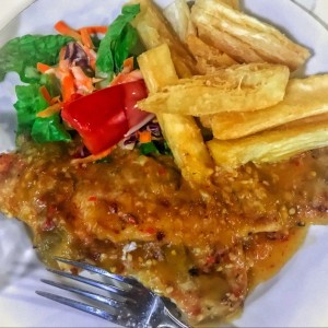 filete de pescado al ajillo con ensalada y yuca frita