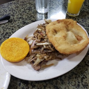 Bistec encebollado con hojaldre y tortilla 