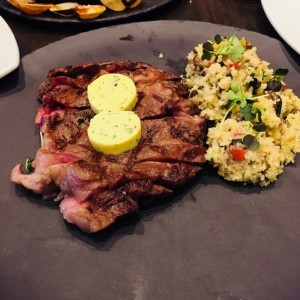 Rib eye angus con mantequilla de albahaca y cous cous de portobello