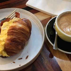 croissant con huevo y tocino y capuchino con leche de almendras