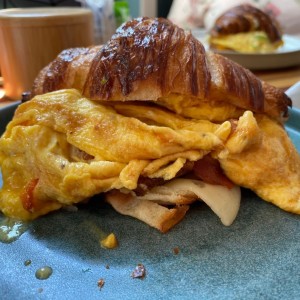 Croissant con huevo revuelto, tomate y bacon. 