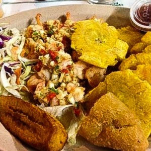 Camarones al ajillo con ensalada, patacones y tajada