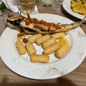 Corvina entera frita con yuquitas.